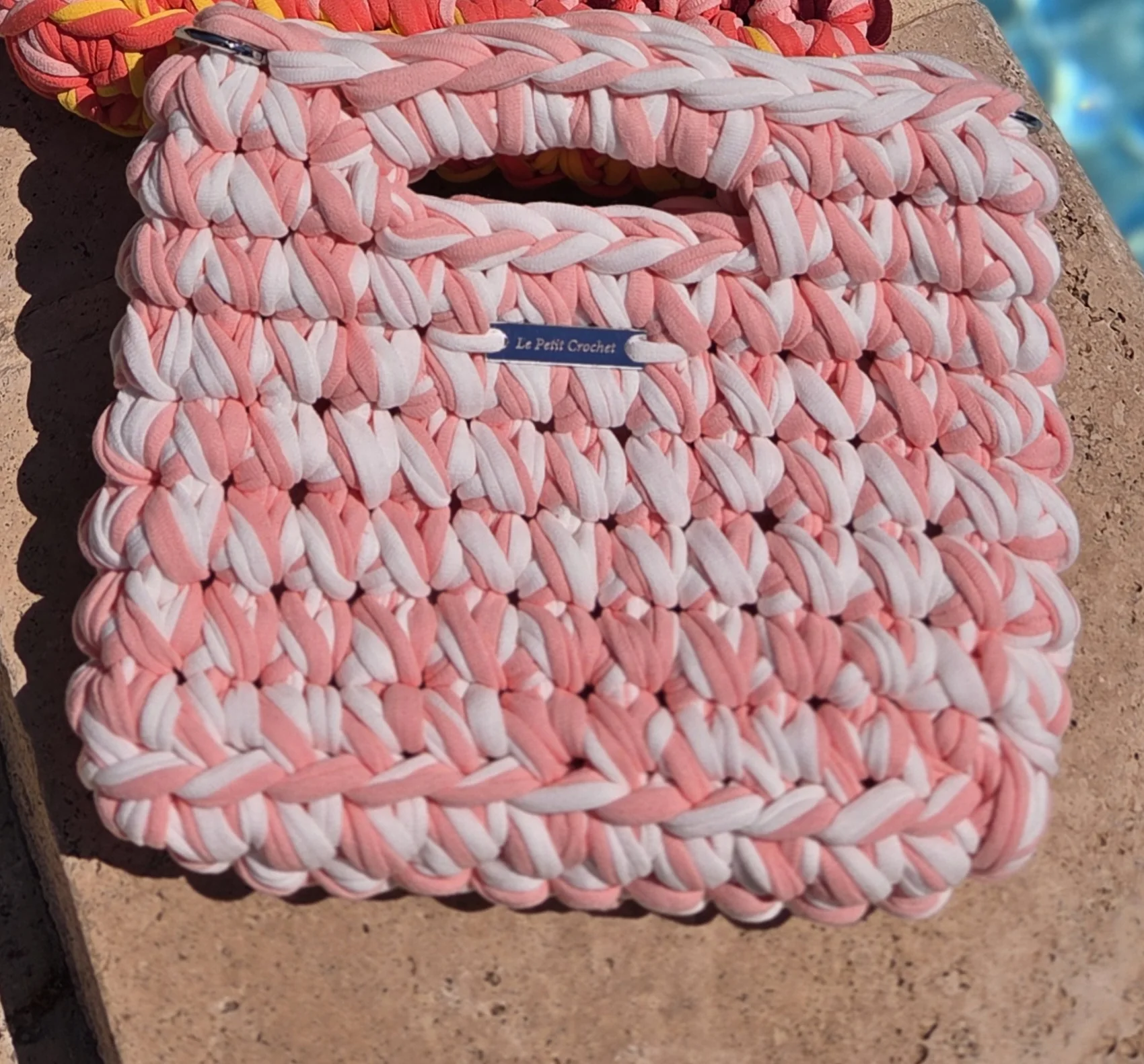 Mini Malia au crochet, pièce unique Fraise : pêche et blanc, plaque bleu marine, au bord d'une piscine